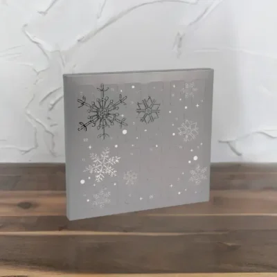 Silver cookie advent calendar with intricate snowflake designs, ideal for festive season gifting from Kakes & Kanvas