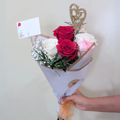 A beautifully arranged Valentine’s Floral Bouquet featuring red, white, and pink roses, accented with baby’s breath and wrapped in elegant packaging.